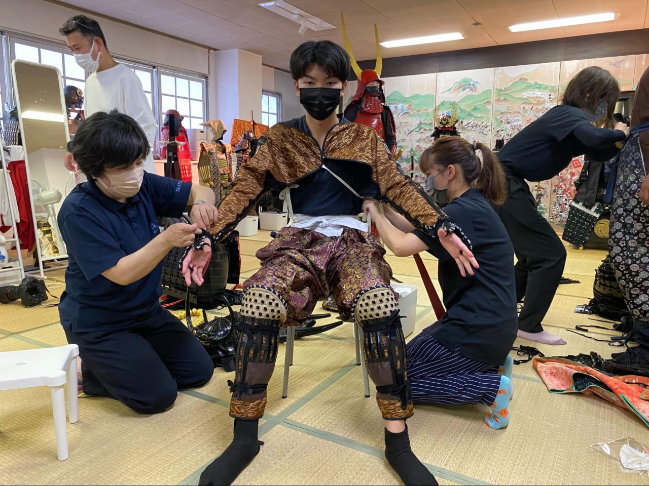 専用の作務衣に着替え、スタッフの方に装束を着付けしていただきます。